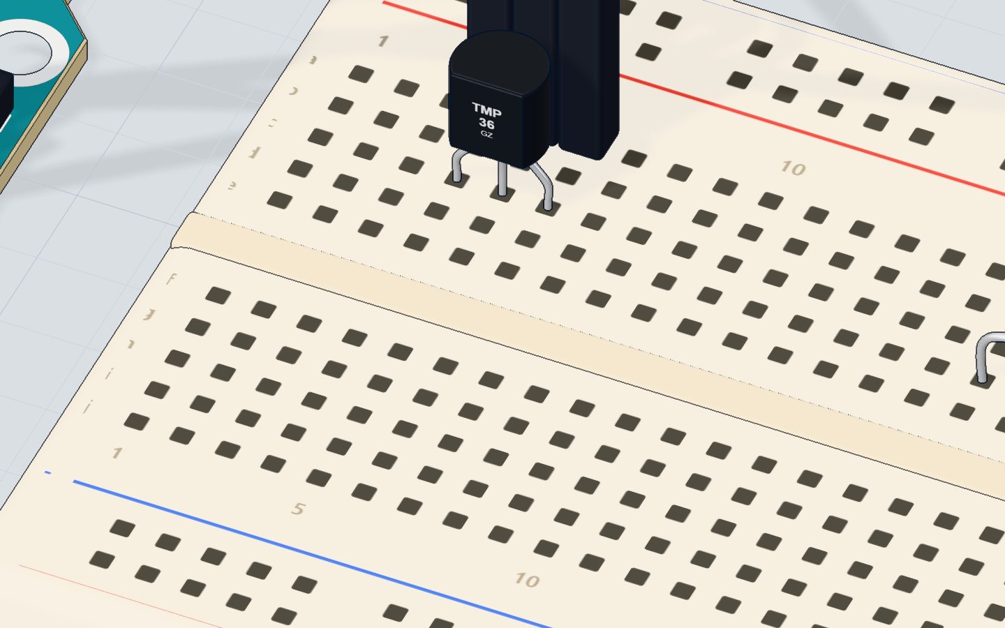 Close-up of the TMP36 temperature sensor on the breadboard with the hairdryer nearby